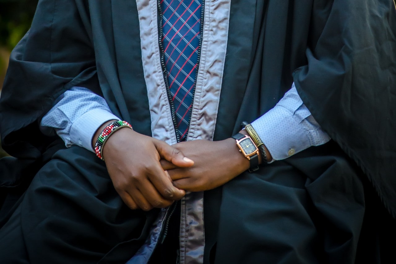 a man’s arms wearing formal clothes and a tank shape watch