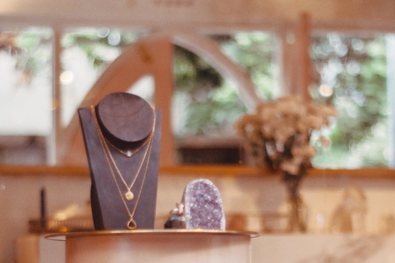 a necklace display at a jewelry store seen through a window